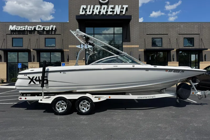 Slide: The Image of 2006 MasterCraft X-45 boat on trailer, parked outside dealership under clear sky. - 2
