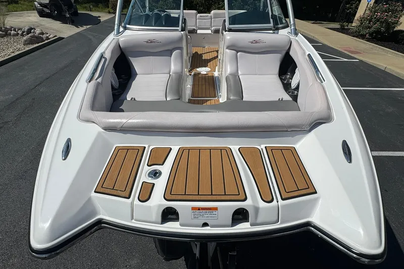 Slide: The Image of 2006 MasterCraft X-45 boat with sleek seating and teak accents, parked on pavement. - 20