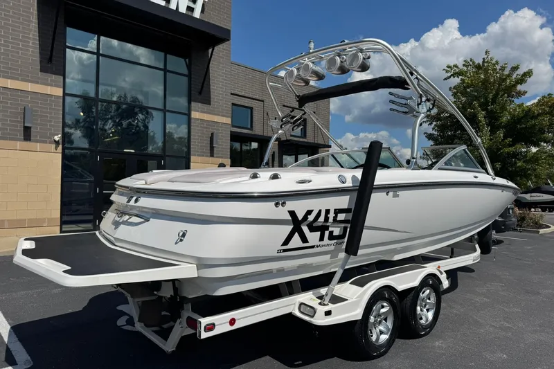 Slide: The Image of 2006 MasterCraft X-45 boat on trailer, parked outside a modern building. - 3