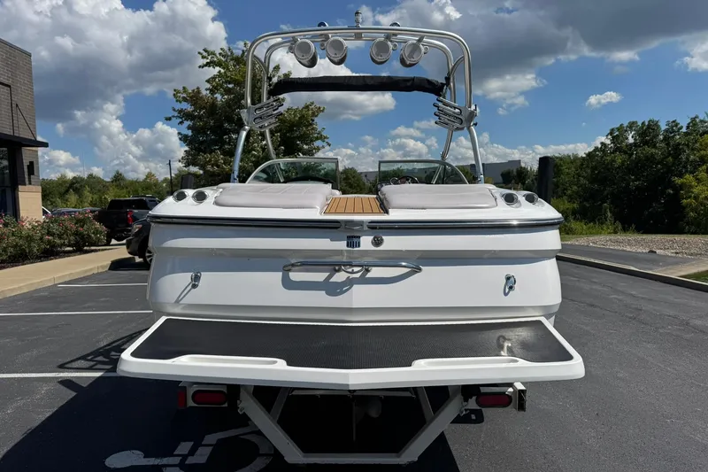 Slide: The Image of 2006 MasterCraft X-45 boat, rear view, parked outdoors under a partly cloudy sky. - 4