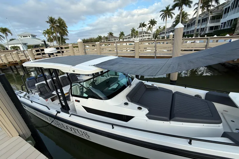 Slide: The Image of 2020 Axopar 37 Sun-Top boat docked, featuring sleek design and spacious seating. - 10