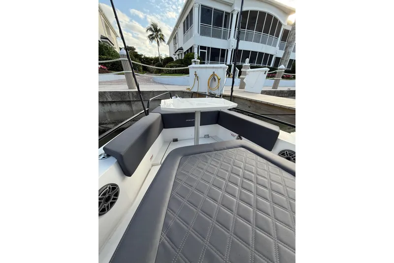 Slide: The Image of 2020 Axopar 37 Sun-Top boat with rear seating and dual engines at a marina. - 16