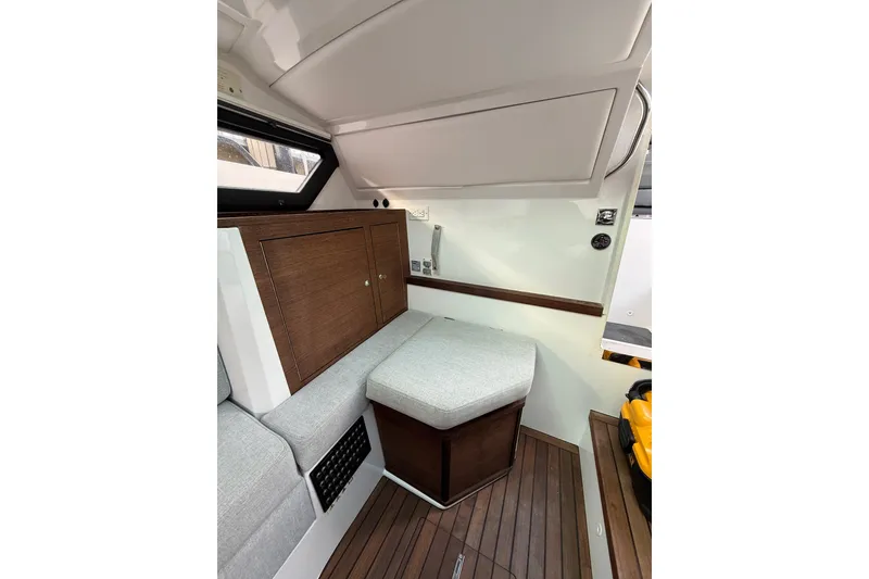 Slide: The Image of 2020 Axopar 37 Sun-Top cabin interior with wooden cabinetry and bed. - 17