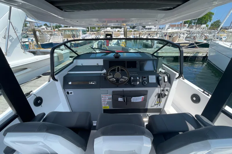 Slide: The Image of 2020 Axopar 37 Sun-Top boat docked near palm trees and waterfront buildings. - 2