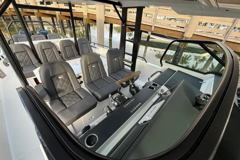 Slide: The Image of 2020 Axopar 37 Sun-Top boat docked at a marina under a clear blue sky. - 23