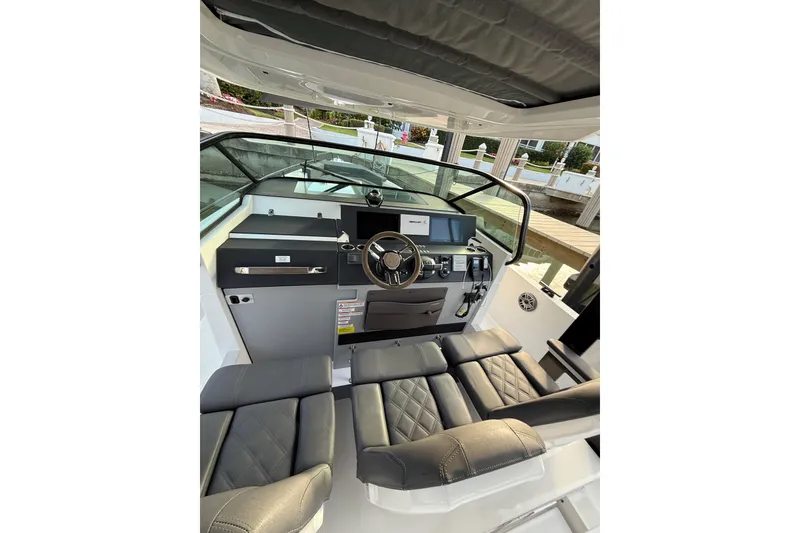 Slide: The Image of 2020 Axopar 37 Sun-Top boat docked, featuring sleek design and sunshade, surrounded by palm trees. - 31