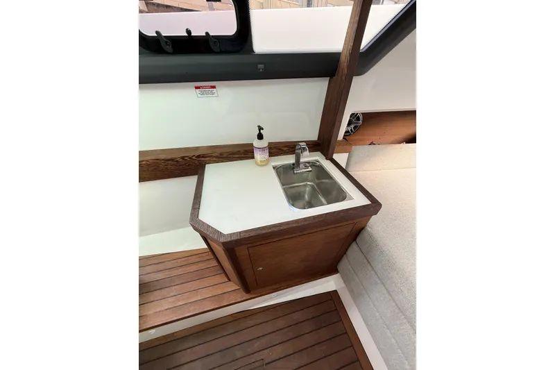 Slide: The Image of 2020 Axopar 37 SUN TOP BRABUS interior with seating, docked near other boats. - 8