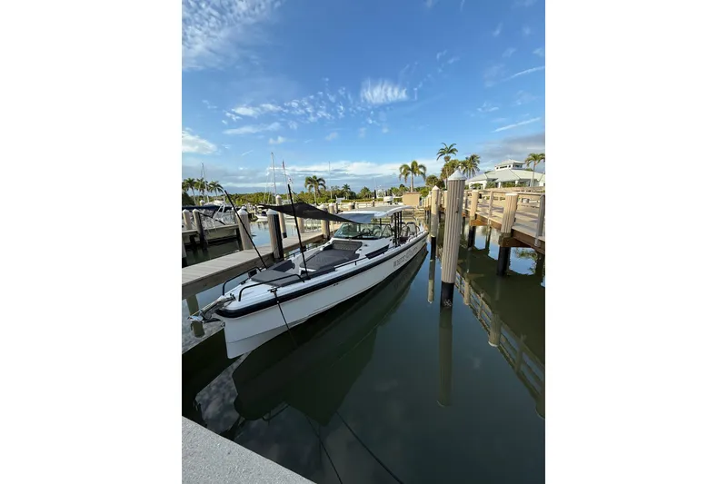 Slide: The Image of 2020 Axopar 37 SUN TOP BRABUS boat docked, featuring sleek seating and modern design. - 9