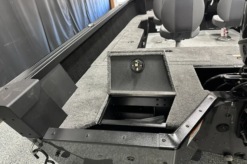 Slide: The Image of 2026 Alumacraft Competitor 185X Side Console interior with storage compartment and seating. - 13