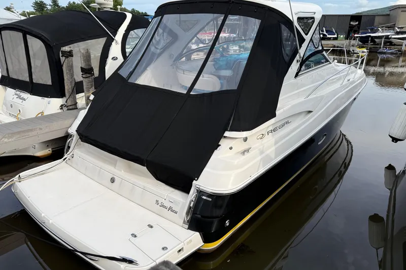 Slide: The Image of 2007 Regal Commodore 3760 IO boat docked with black canopy cover. - 2