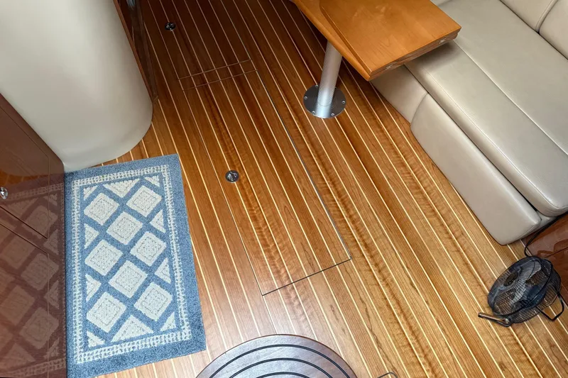 Slide: The Image of 2007 Regal Commodore 3760 IO interior with wooden flooring, rug, and beige seating. - 9