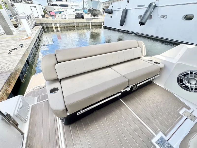 Slide: The Image of 2015 Regal 35 Sport Coupe boat with beige seating and cup holders at a marina. - 11