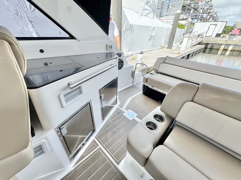 Slide: The Image of 2015 Regal 35 Sport Coupe interior with seating, cup holders, and dockside view. - 16