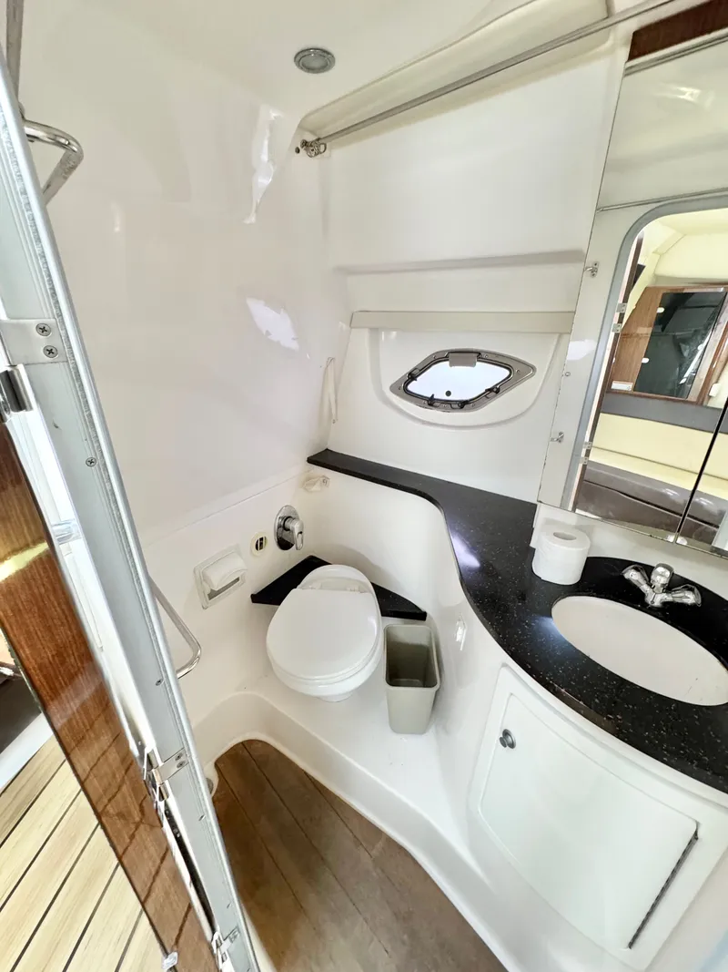 Slide: The Image of 2015 Regal 35 Sport Coupe bathroom with toilet, sink, and porthole window. - 26