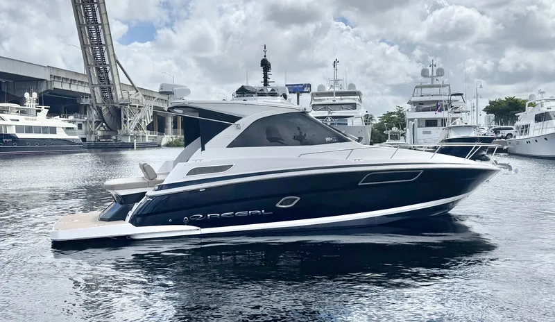 Slide: The Image of 2015 Regal 35 Sport Coupe yacht docked in a marina, surrounded by other boats. - 3