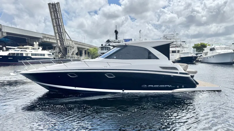 Slide: The Image of 2015 Regal 35 Sport Coupe yacht docked in marina, under cloudy sky. - 6