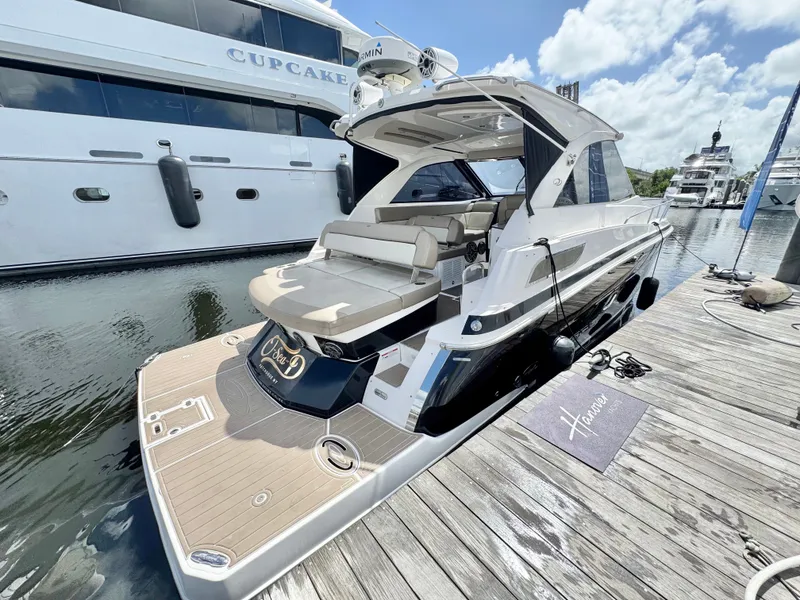 Slide: The Image of 2015 Regal 35 Sport Coupe docked at marina, featuring sleek design and spacious deck. - 9