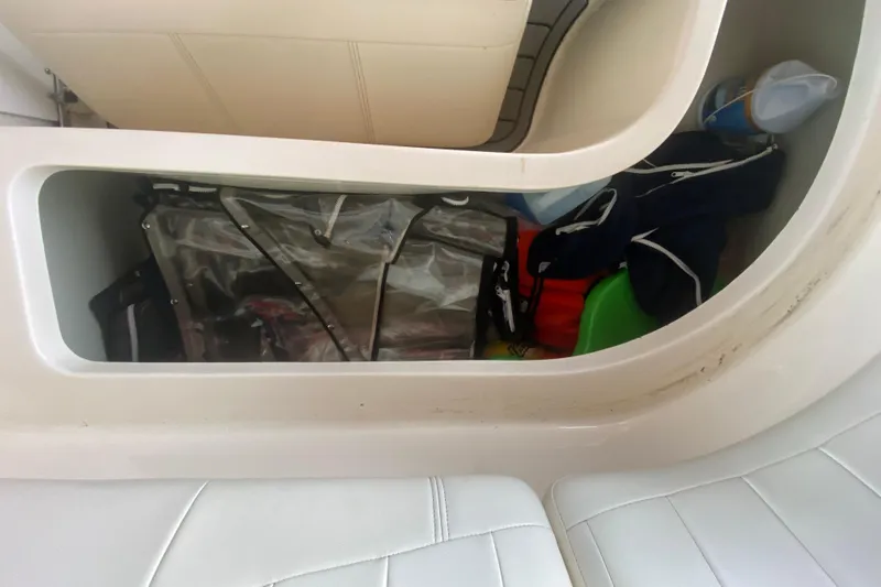 Slide: The Image of Storage compartment in a 2002 Rinker 342 Fiesta Vee boat, containing various items. - 10