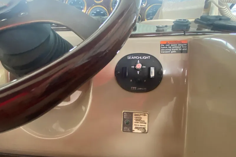 Slide: The Image of 2002 Rinker 342 Fiesta Vee dashboard with searchlight controls and warning label. - 21