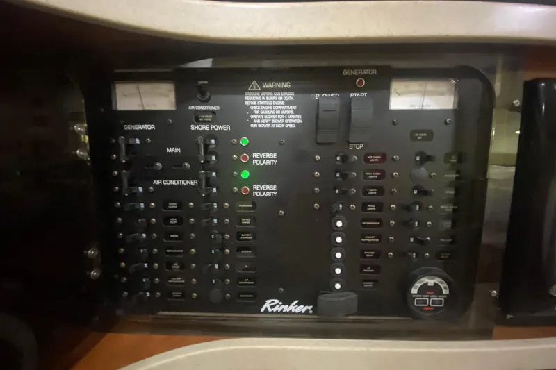 Slide: The Image of Control panel of a 2002 Rinker 342 Fiesta Vee boat, featuring generator and shore power switches. - 26