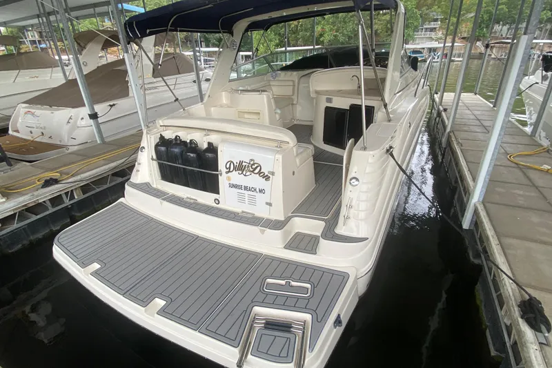 Slide: The Image of 2002 Rinker 342 Fiesta Vee boat docked, featuring spacious deck and seating area. - 3