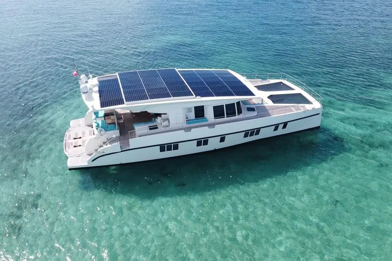 Slide: The Image of Solar-powered Serenity 64 yacht from 2018 on clear turquoise waters. - 11