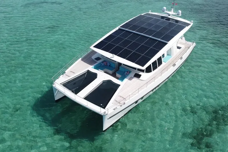 Slide: The Image of Solar-powered Serenity 64 yacht from 2018 on clear turquoise waters. - 12