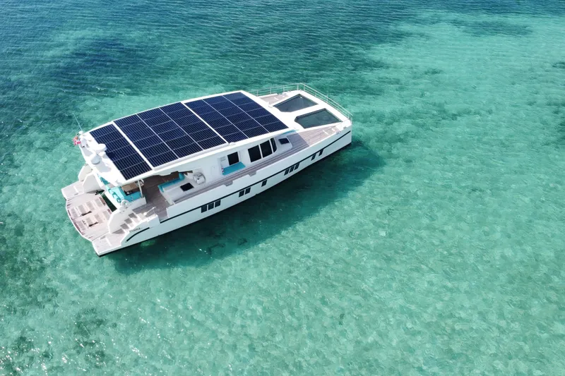 Slide: The Image of Solar-powered Serenity 64 yacht from 2018 on clear turquoise waters. - 13