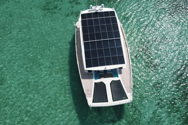 Slide: The Image of Aerial view of 2018 Serenity 64 yacht with solar panels on turquoise water. - 15