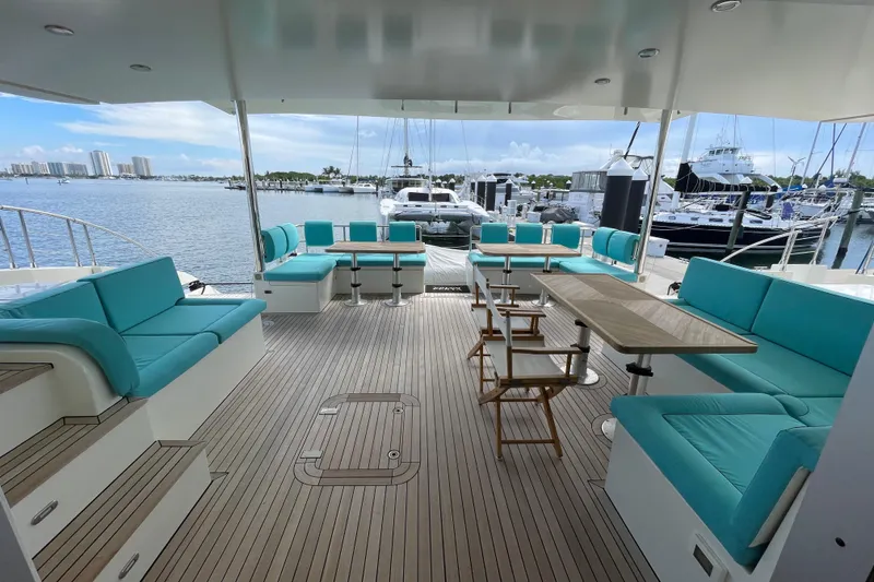Slide: The Image of Spacious deck of 2018 Serenity 64 yacht with turquoise seating and marina view. - 16