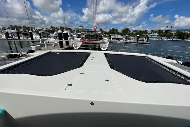Slide: The Image of Serenity 64 yacht docked at marina, showcasing spacious deck and clear blue sky. - 26