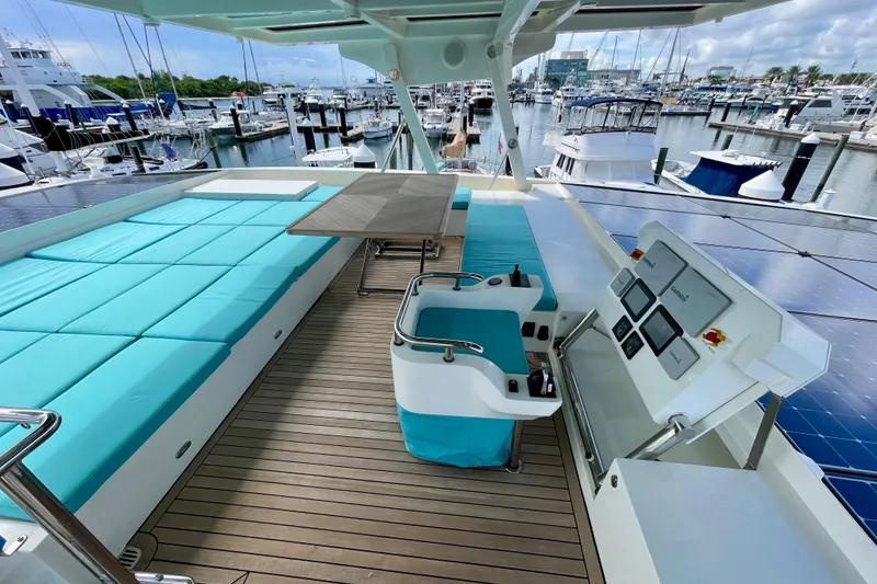 Slide: The Image of Luxurious Serenity 64 yacht deck with turquoise seating, solar panels, and marina view. - 28