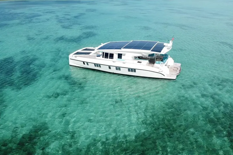 Slide: The Image of Solar-powered Serenity 64 yacht from 2018 on clear turquoise waters. - 3