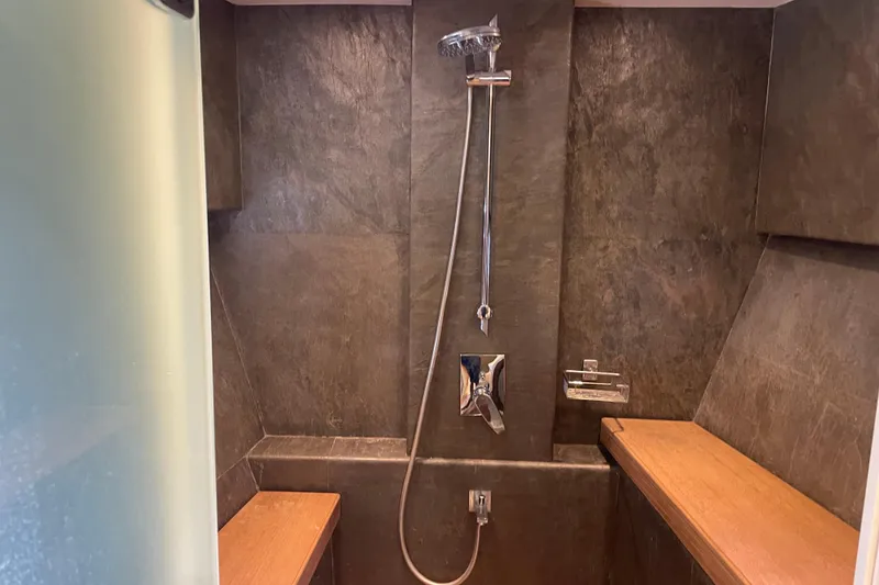 Slide: The Image of Luxurious shower area in 2018 Serenity 64 yacht with modern fixtures and wooden accents. - 54