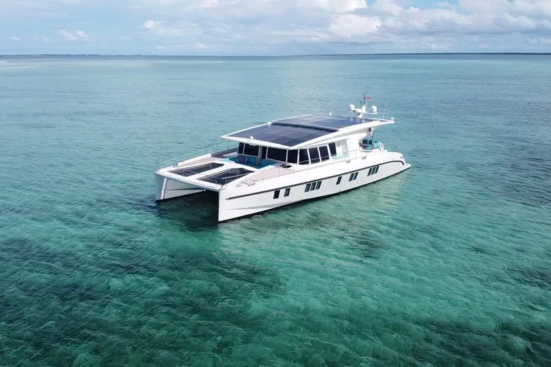 Slide: The Image of Luxurious 2018 Serenity 64 yacht on clear turquoise waters under a partly cloudy sky. - 6