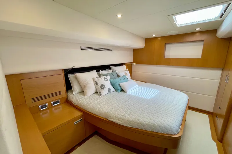 Slide: The Image of Luxurious bedroom interior on 2018 Serenity 64 yacht, featuring elegant wood finishes and plush bedding. - 68