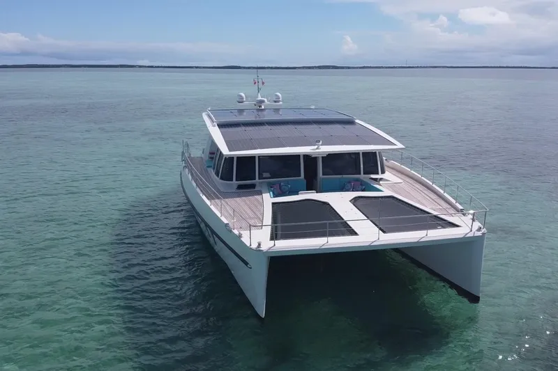 Slide: The Image of 2018 Serenity 64 yacht with solar panels on calm ocean waters. - 7