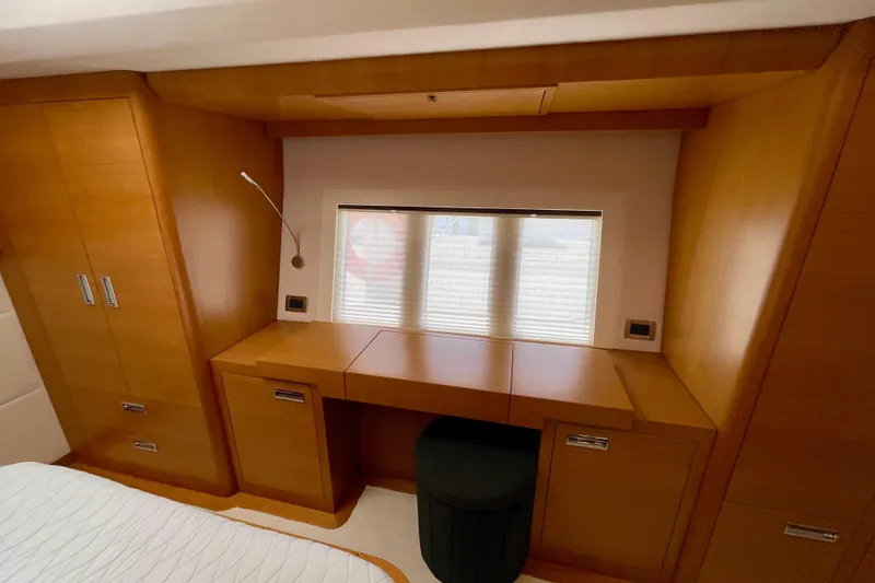 Slide: The Image of Luxurious wooden interior of a 2018 Serenity 64 yacht cabin with desk and storage. - 71