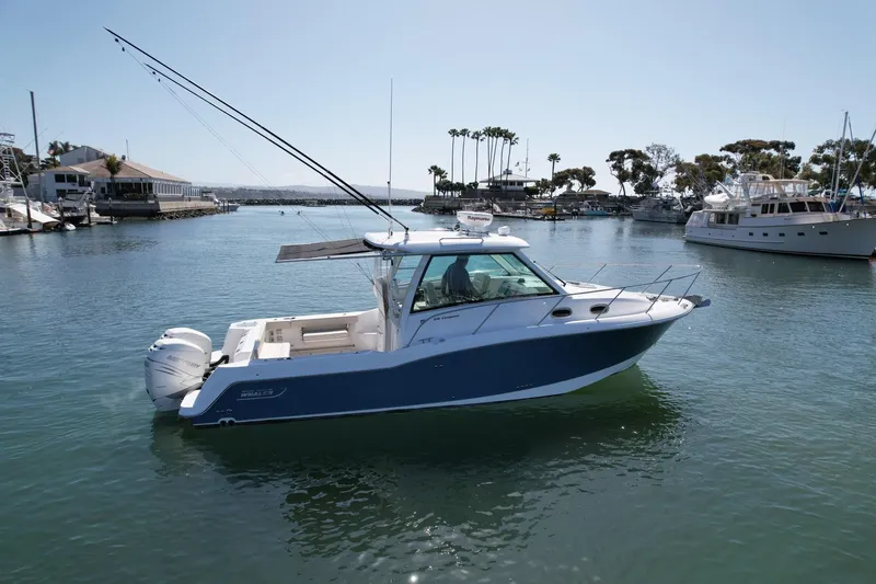 Slide: The Image of 2018 Boston Whaler 315 Conquest boat on calm water in a marina setting. - 10