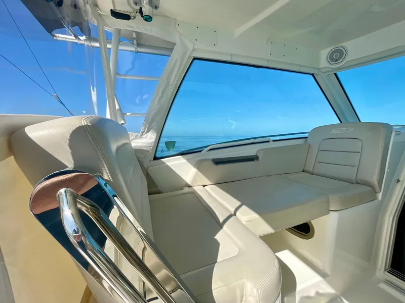Slide: The Image of Interior view of 2018 Boston Whaler 315 Conquest boat with white seating and ocean backdrop. - 15
