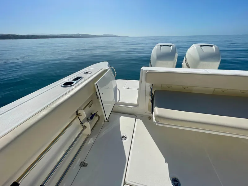 Slide: The Image of 2018 Boston Whaler 315 Conquest boat deck with twin engines on calm sea. - 24