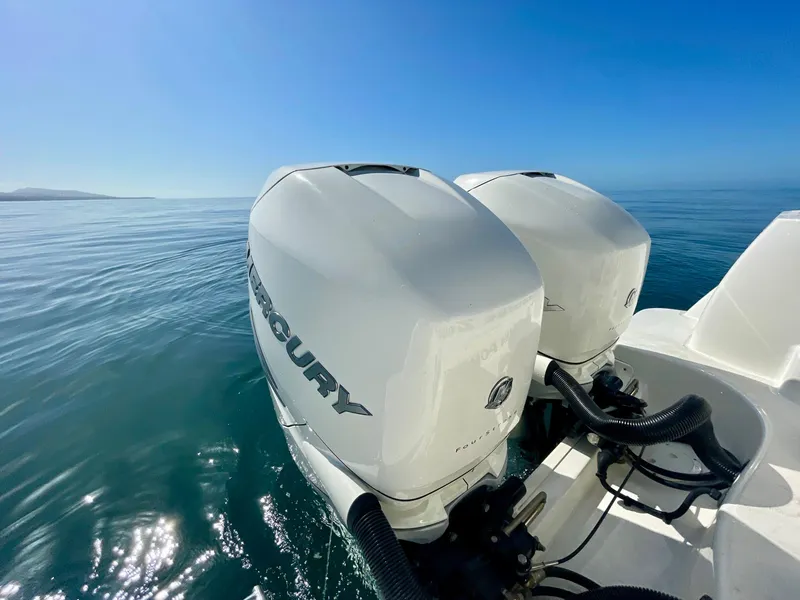 Slide: The Image of Twin Mercury outboard engines on a 2018 Boston Whaler 315 Conquest, cruising on calm waters. - 29