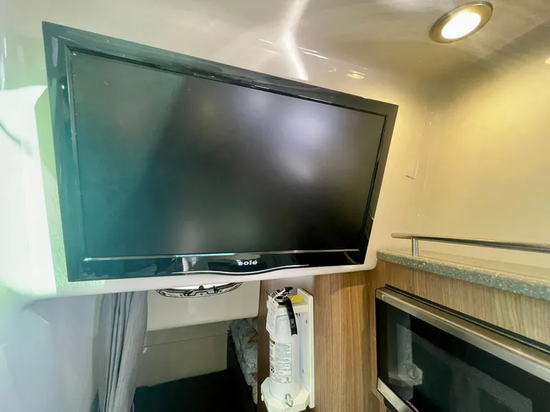 Slide: The Image of 2018 Boston Whaler 315 Conquest cabin interior with mounted TV and modern amenities. - 41