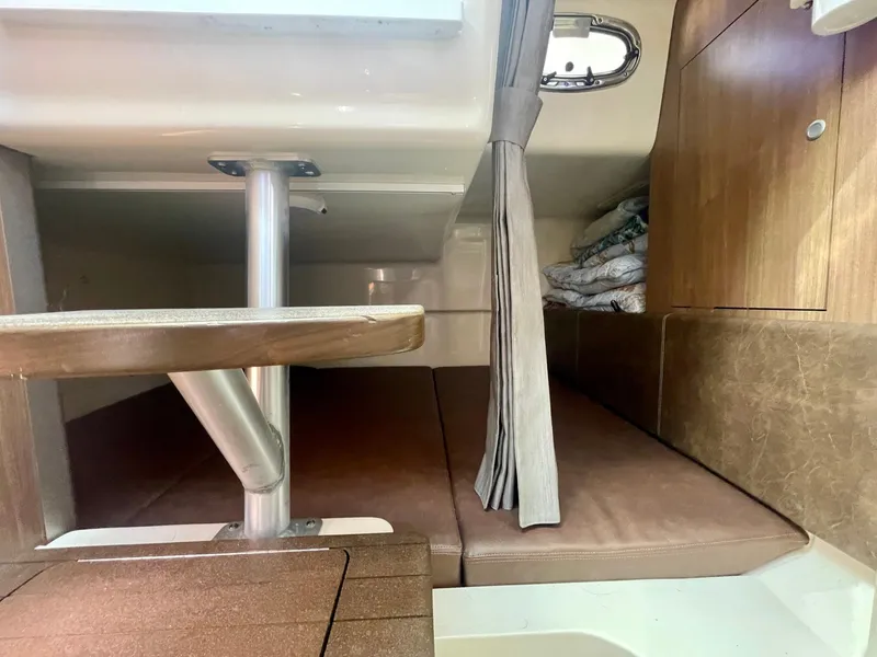 Slide: The Image of 2018 Boston Whaler 315 Conquest cabin interior with seating and wooden finishes. - 42