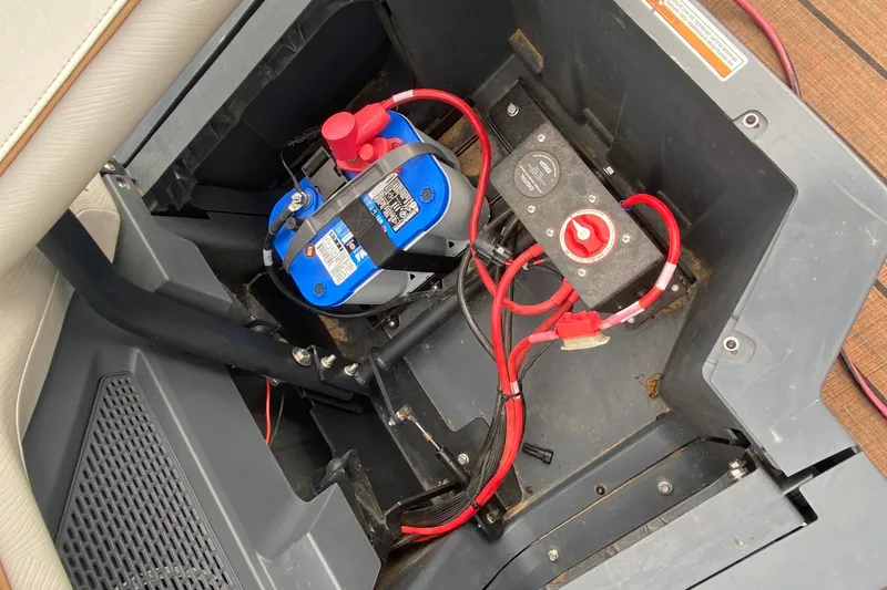 Slide: The Image of Battery compartment of 2024 Manitou 22 MAX Explore Navigator Stealth with wiring and switch. - 26