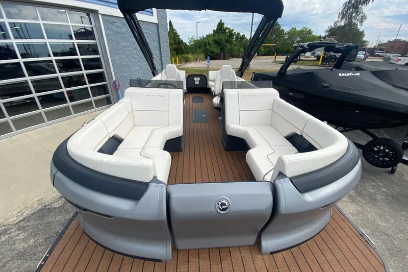 Slide: The Image of 2024 Manitou 22 MAX Explore Navigator Stealth pontoon boat with luxurious seating and sleek design. - 8