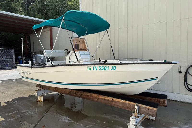 Slide: The Image of 2006 Key Largo 160 Center Console boat with teal canopy on wooden stand. - 2