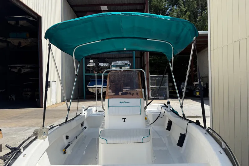 Slide: The Image of 2006 Key Largo 160 Center Console boat with teal canopy in storage facility. - 8