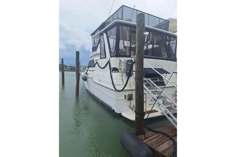 Slide: The Image of 1986 Sea Ray 410 Aft Cabin yacht docked at marina, rear view. - 0