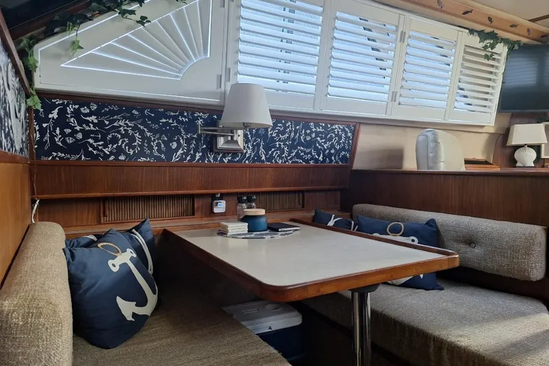 Slide: The Image of 1986 Sea Ray 410 Aft Cabin interior with cozy dining area and nautical decor. - 17